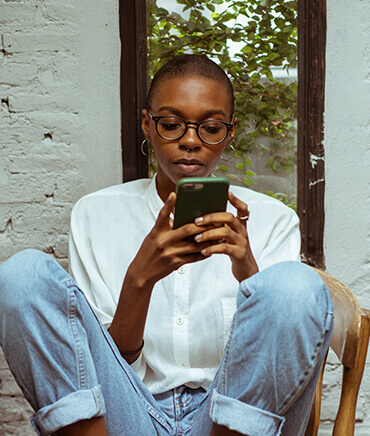 Focused young woman using smartphone in a relaxed business environment